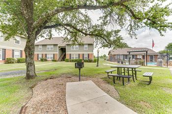 Outdoor picnic area with grill and pool access